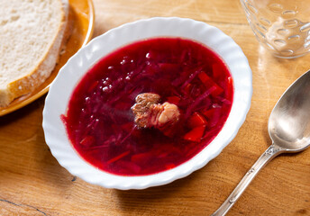 Borsch, beetroot hot soup and bread on the table in a cafe