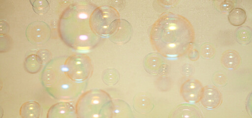Cosmetic bubbles flying on beige background