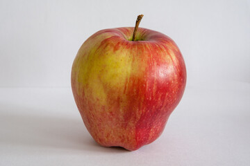 Close-up one red apple on a gray background for publication, poster, calendar, post, screensaver, wallpaper, cover. High quality photo