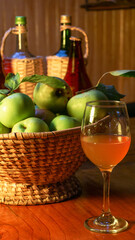 A composition of bottles, glass of cider and apples