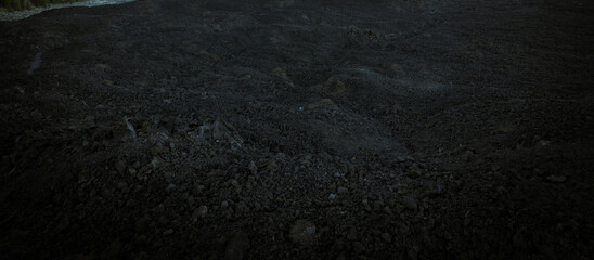 Black basalt lava formations, rocks, stones and sand, closeup view of volcanic dark terrain.