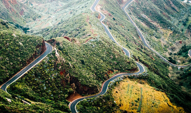 A scenic view on a road among the mountains covered with tropical green forest.