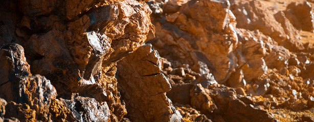 Lava formations, stones, black basalt in the rocks closeup on a volcano terrain.