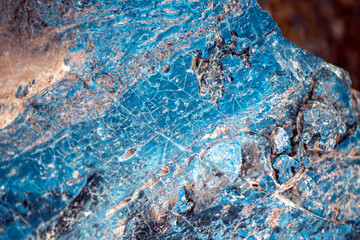 A blue natural stone with lots of details closeup, a piece of volcanic origin stone.