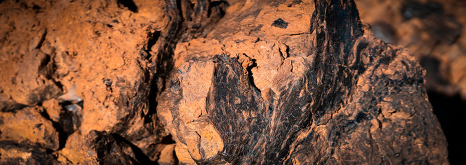 Lava formations, stones, black basalt in the rocks closeup on a volcano terrain.