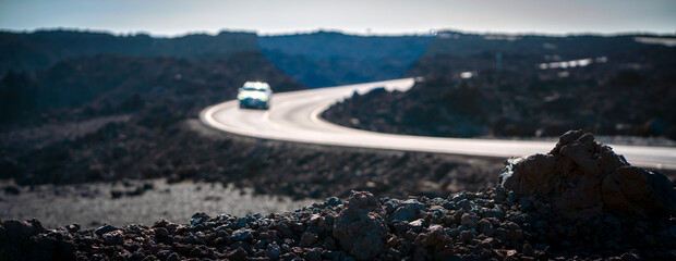 A beautiful asphalt road among black volcanic landscapes with lava formations.