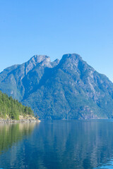 Obraz premium Peaceful waters and large mountain peak in the distance