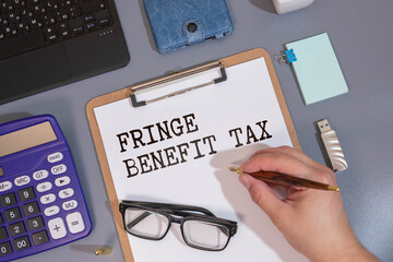 Fringe Benefit Tax write on a book isolated on Wooden Table