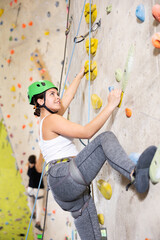 young climber woman climbing up indoors bouldering wall at fitness gym .healthy lifestyle concept