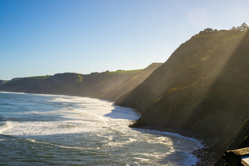 Sunlight pours through white cliffs into the ocean