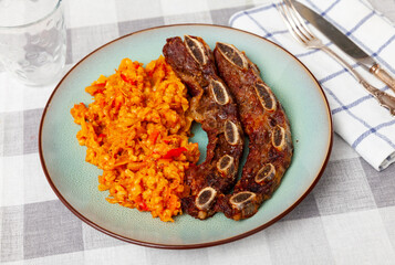 Traditional Spanish dish is churasco. Grilled beef ribs topped with pearl barley and vegetables....