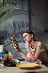 Elegant woman enjoying a lobster dinner at a stylish table in a cozy restaurant setting