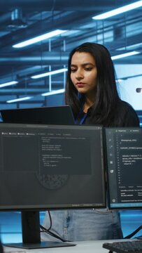 Vertical video Cheerful supervisor in server room managing multiethnic team of technicians looking for equipment misconfigurations. Upbeat team leader coordinating workers fixing data center
