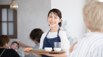 Fototapeta premium カフェや飲食業、レストランのスタッフ カメラ目線 転職や求人の募集などのイメージ 楽しく働く