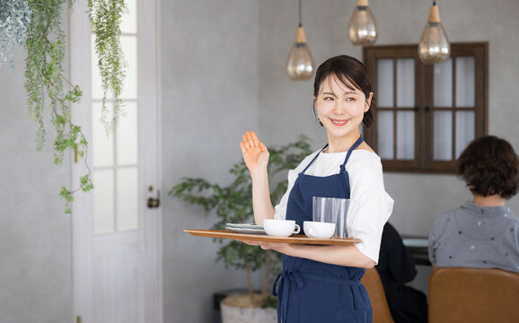 いらっしゃいませとお客を案内するカフェや飲食業、レストランのスタッフ　転職や求人の募集などのイメージ