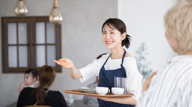 いらっしゃいませとお客を案内するカフェや飲食業、レストランのスタッフ　転職や求人の募集などのイメージ