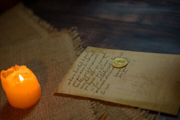 An antique letter with a coin in the light of a burning candle