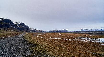 panoramic view of gravel road and glacier in iceland
