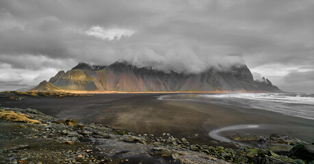 Vestrahorn beach with the mountain in the background with clouds on a gray day