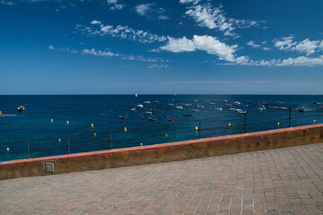 Promenade in Calella de Palafrugell, in the background the sea with boats at anchor. Costa Brava in Catalonia Spain.