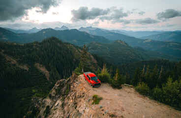 Aerial shot of shot of a pickup truck standing on the cliff with a backdrop of North Cascades...