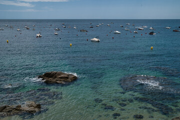 Boats anchored near the rocky beach in Calella de Palafrugell, a fishing village on the Costa Brava in Catalonia, Spain.
