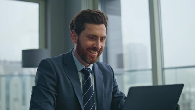 Smiling man working laptop at luxury workplace closeup. Startuper drinking tea