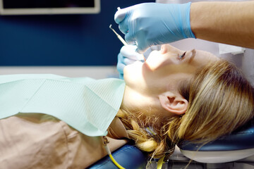 Dentist and patient at modern medical center. Doctor treats a young woman teeth in hospital....