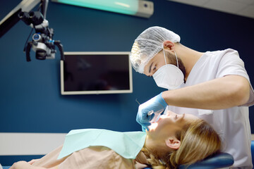 Dentist and patient at modern medical center. Doctor treats a young woman teeth in hospital....