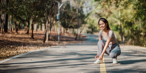A woman is kneeling on the road, putting on her shoes. The scene is peaceful and serene, with the...