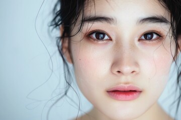 Asian woman with eyes closed in serene meditation on white background for beauty and wellness concept