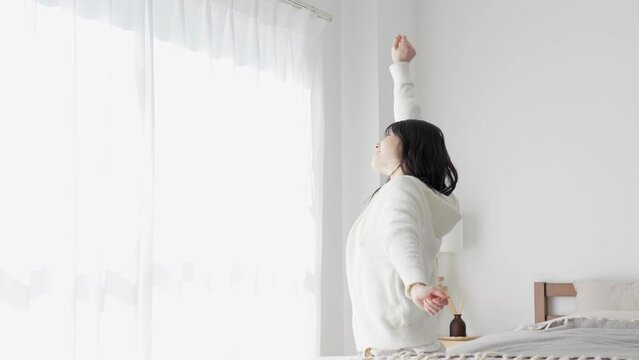朝起きて伸びをする女性