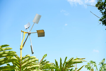 Windmill in a rural tropical setting. Concept: renewable energy generation. Composition with copy...
