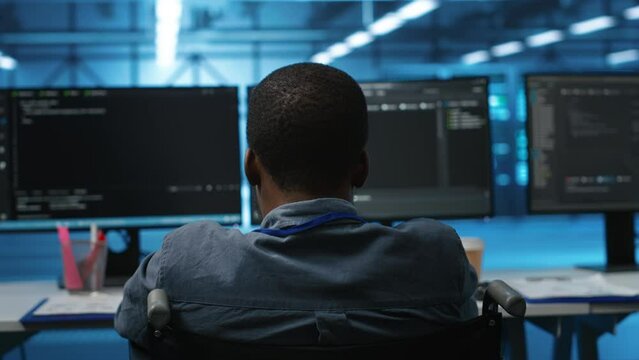 African american person with impairment in server farm ensuring data remains shielded from threats. Close up shot of wheelchair user safeguarding data center hardware against unauthorized access