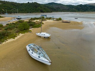 Boats morred on the sand at low tide in Sandy bay, Marahau, Motueka, Tasman, New Zealand. © Zenstratus