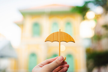Model of umbrella with blur house on background, concept of the system of insurance savings and...