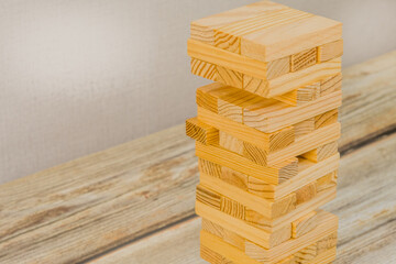 Closeup of tower of wooden blocks on a wooden tabletop. Generic version of popular game.