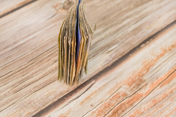 A folded stack of currency notes on a wooden table