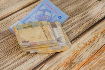 A stack of currency notes laying on a wooden table