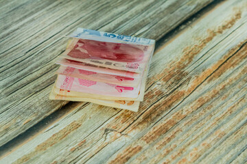 A folded stack of Turkish currency notes on a wooden table surface