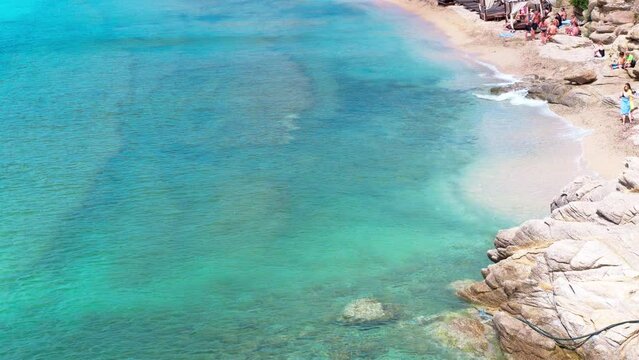 Paraside Beach in Mikonos, Greece, umbrella and luxury beach chairs beds in front of blue ocean. Most famous beach with crystal water and beach music bars. Gimbal cinematic ProRes graded from Log