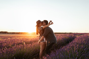 Beautiful romantic photo of a couple in a field of flowers at sunset