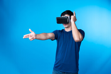 Smart gamer wearing VR turning to metaverse world playing gun shooting hunter isolated blue...