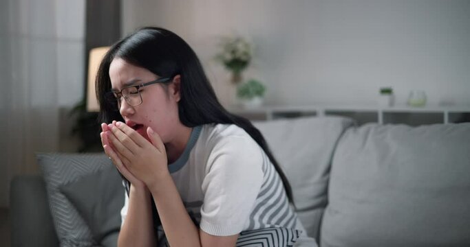 Footage dolly shot, Unwell young woman chronic cough while sitting on sofa at home, Coughing as telltale sign of a cold or bronchitis, healthcare woes