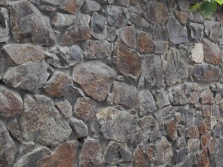 Stone wall. Different in size and shape rocks create a retro atmosphere. Abstract background of stone wall in the old town in Georgia. Walls of stone houses and castles.