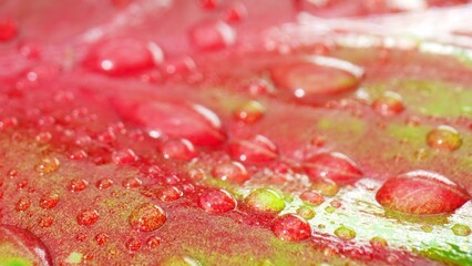 Mesmerizing close-up captures the exquisite beauty of glistening water droplets on lush, wet pink green leaves. Nature's jewels up close. Natural wonders concept. 
