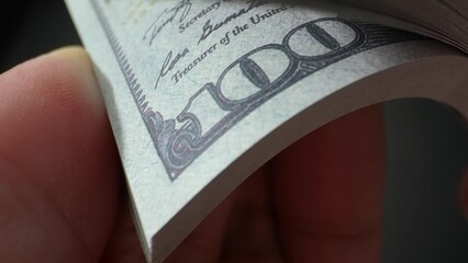 High-energy, fast-paced capturing hands rapidly counting US 100 bills in a thrilling macro view....