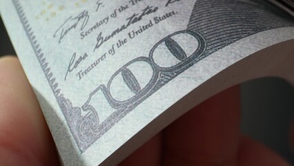 A close-up of hands meticulously counting 100 dollars bills, revealing the hidden art of wealth....