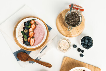 Presented by fruits putting yogurt toppings with strawberry, berry, oats, raisins and chia seed...