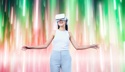 Female standing and wearing white VR headset and white sleeveless connect metaverse, future technology creating cyberspace community. She enjoy looking fantasy light around her. Hallucination.